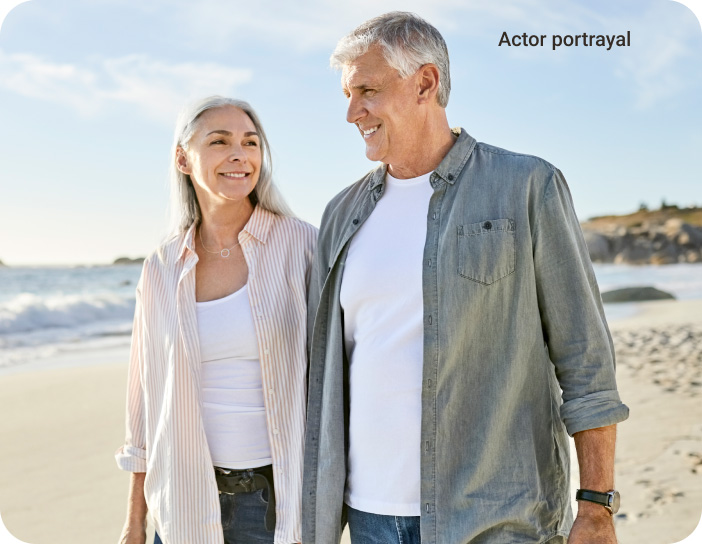 elderly couple walking on the beach