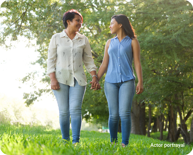 two women walking in the park holding hands