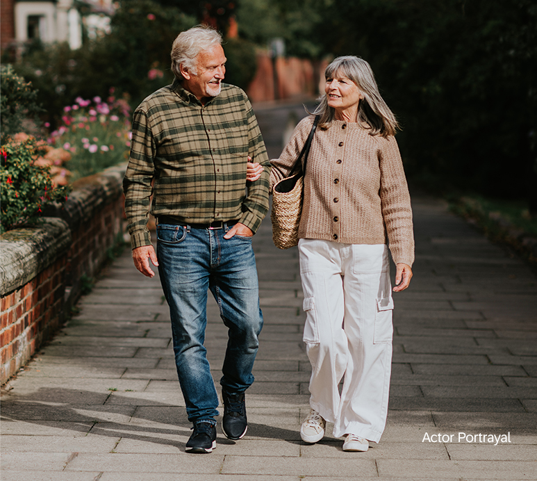 elderly man and woman happily walking