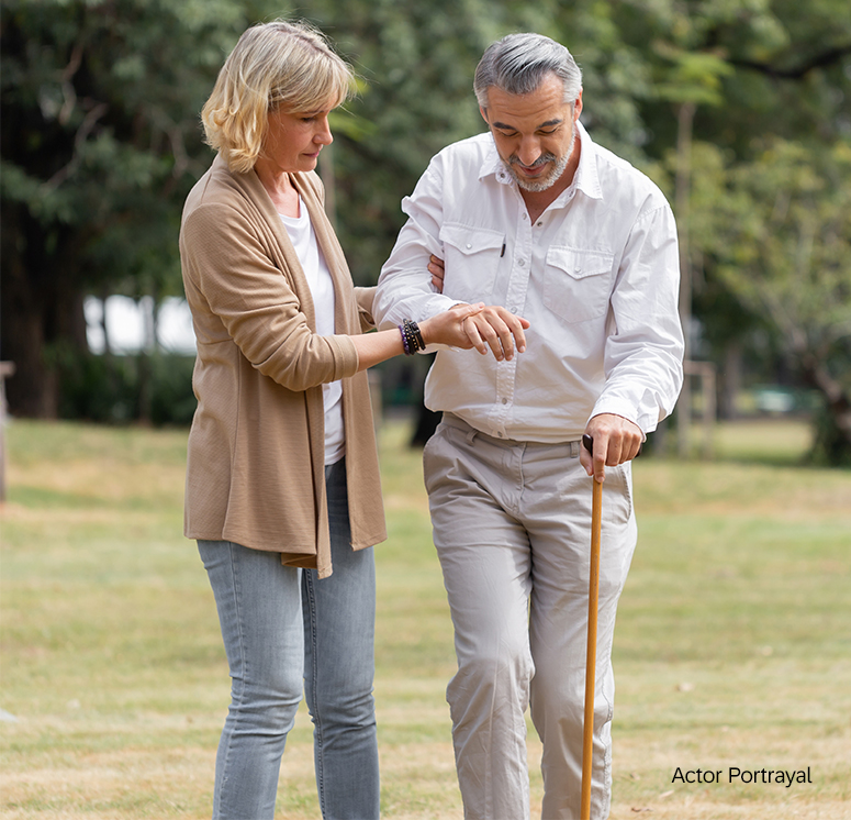 woman helping elderly man walk